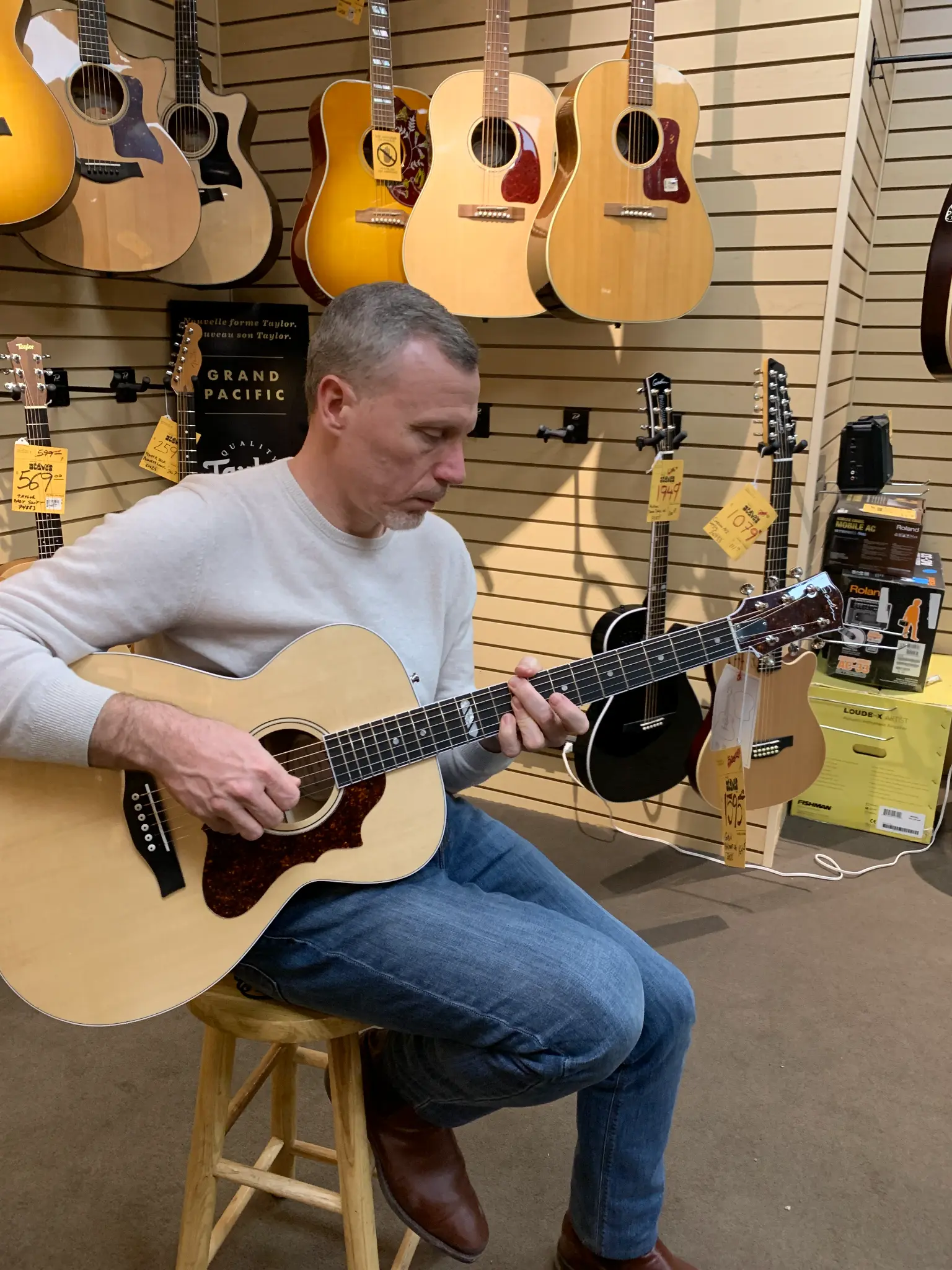 Earle G. Hall playing a Godin guitar in a Quebec music store